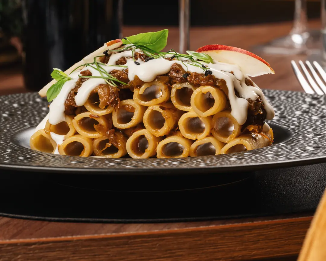 Paccheri al ragù serviti con vino rosso